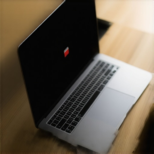 A dark laptop screen showing a low battery icon on a desk